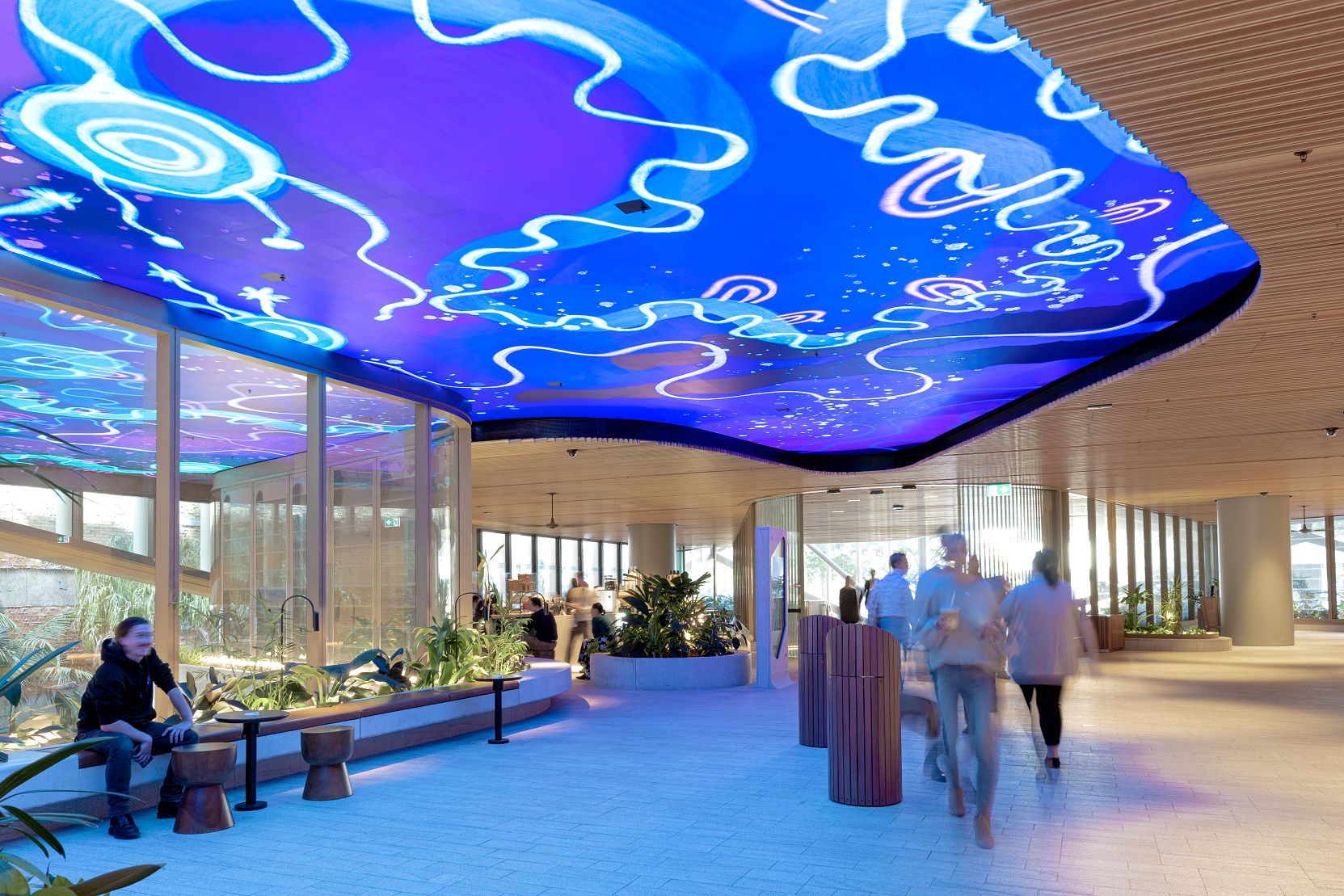 Photo of Mirvac Heritage Lanes commercial lobby foyer in Brisbane Australia showing digital placemaking art screen with vibrant blue indigenous Australian aboriginal artwork created by artist Rachael Sarra in partnership with VANDAL.