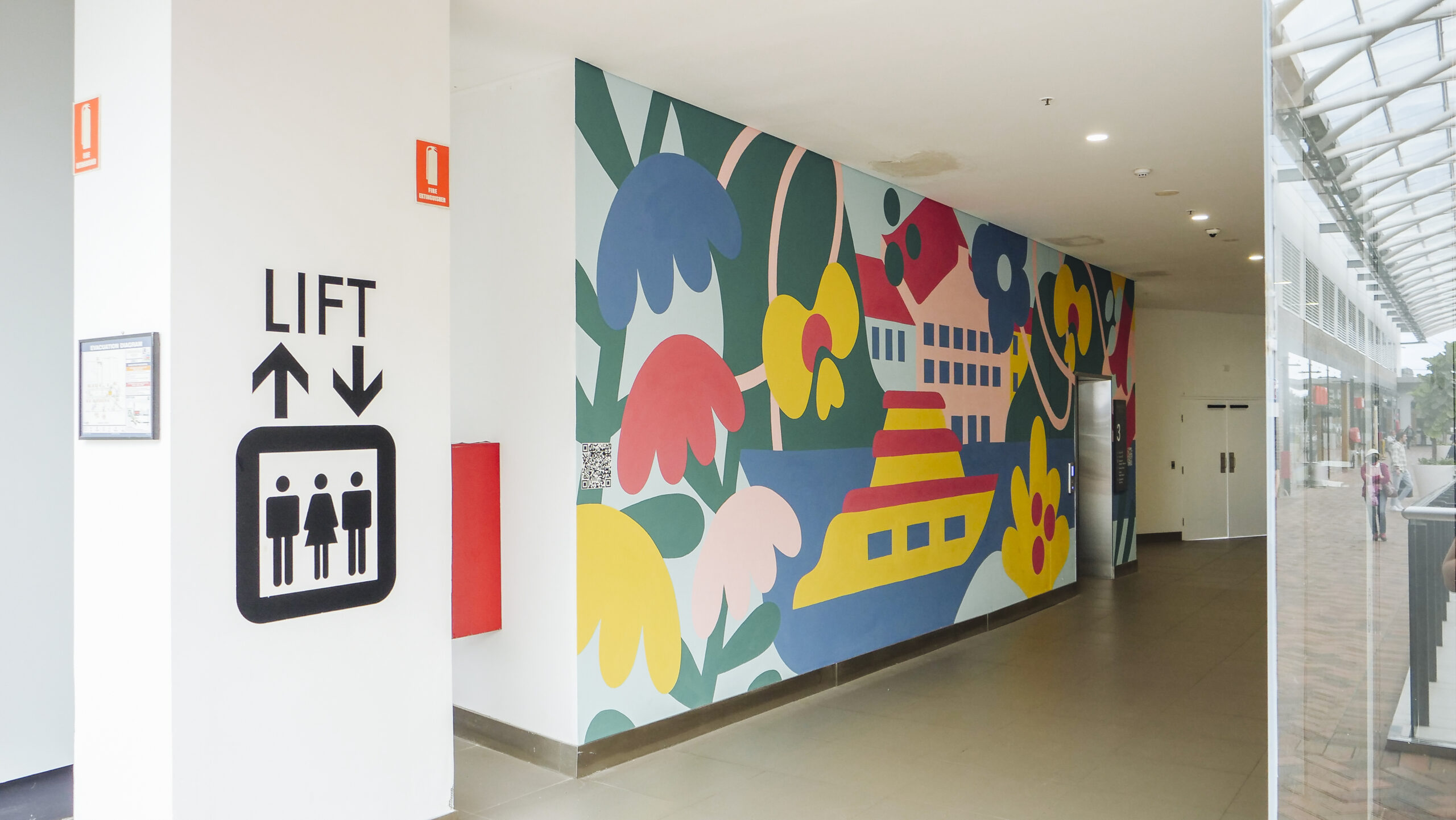 Geometric multicoloured wall mural encapsulating a shopping centre lift produced by VANDAL for Mirvac