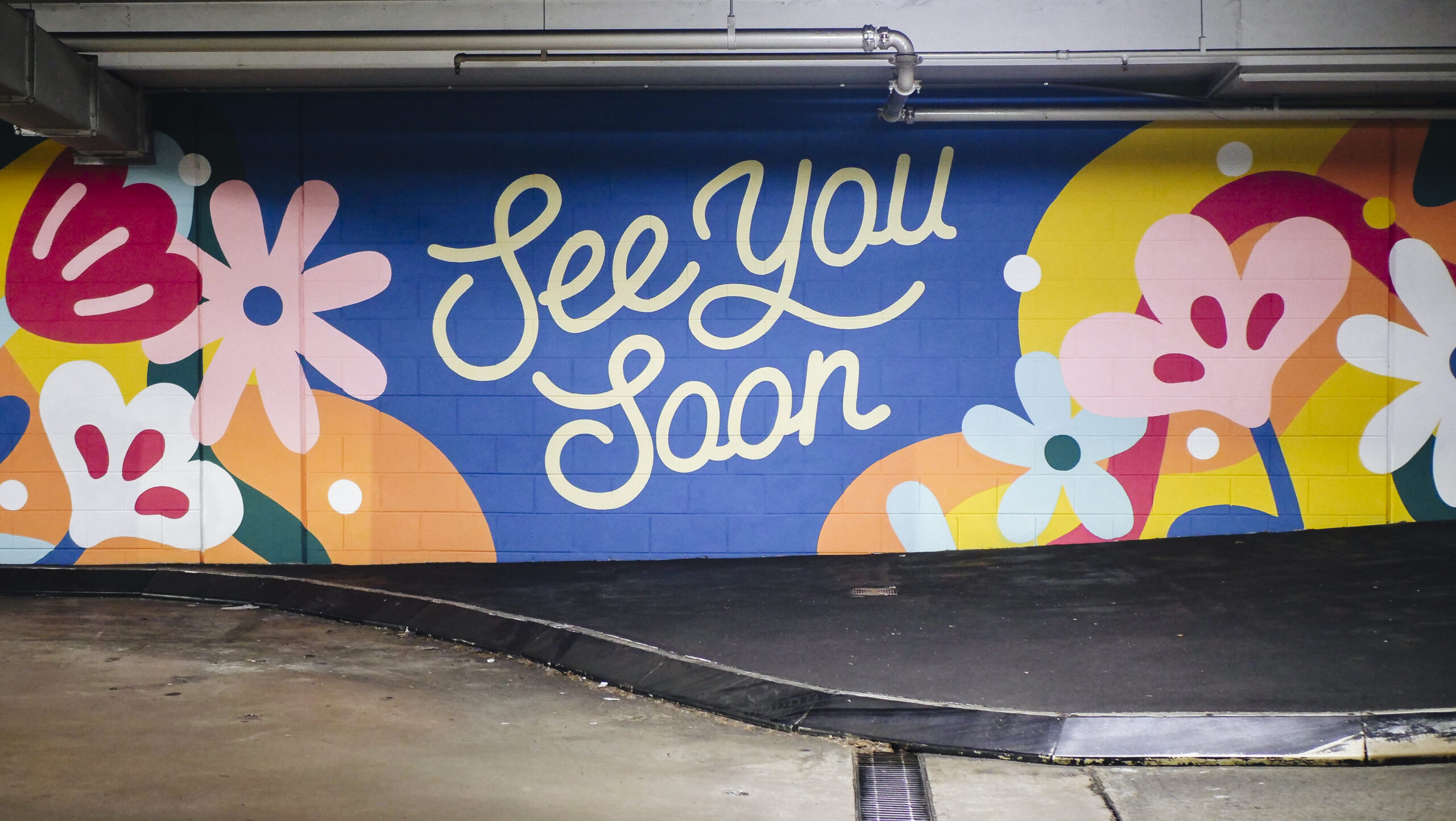 geometric multicoloured wall mural featuring the phrase 'see you soon' produced by VANDAL for Mirvac
