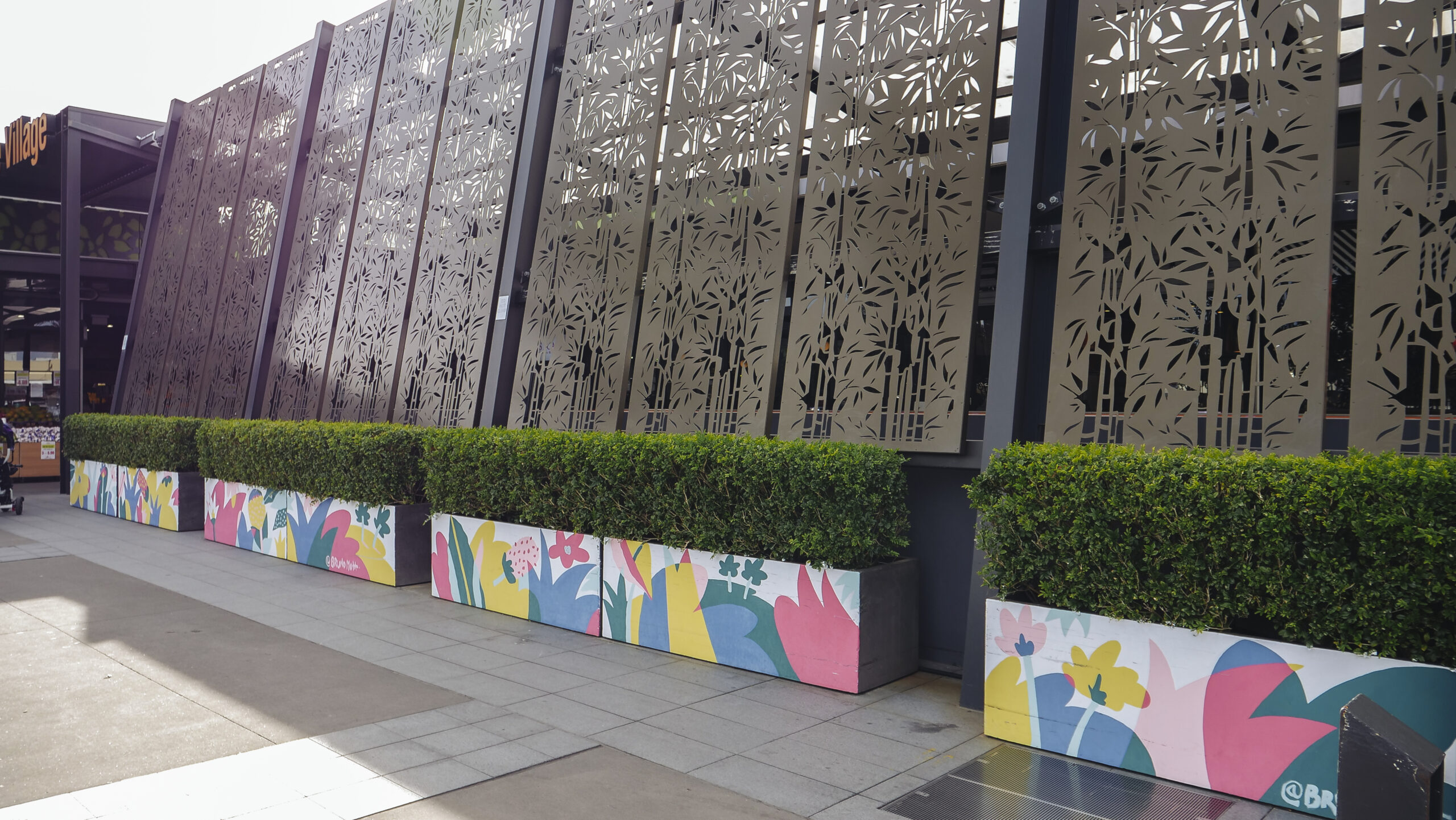 Geometric multicoloured planter box murals holding hedging shrubs produced by VANDAL for Mirvac
