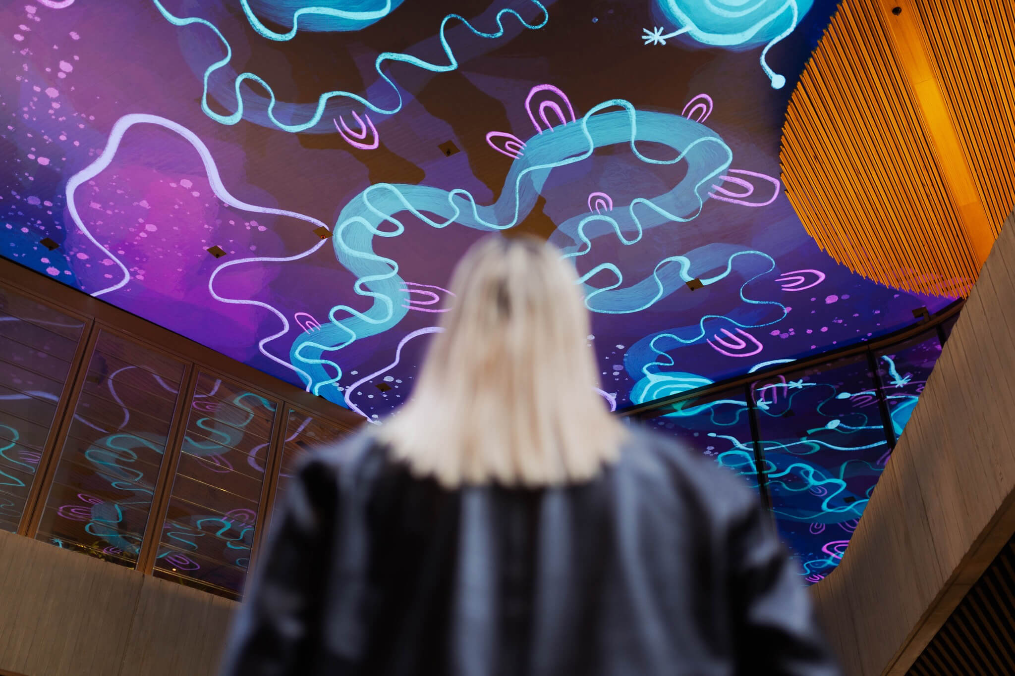 Photo of artist Rachael Sara Mirvac Heritage Lanes commercial lobby foyer in Brisbane Australia showing digital placemaking art screen with vibrant blue indigenous Australian aboriginal artwork created by artist Rachael Sarra in partnership with VANDAL.