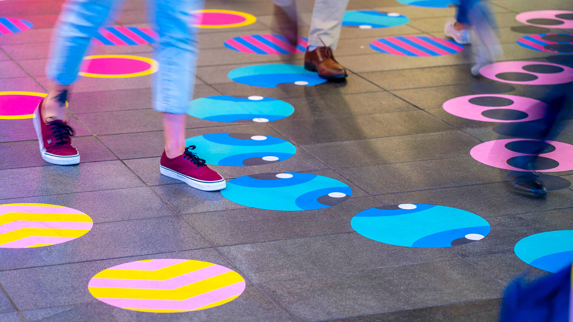 Shoppers enjoying a multicoloured placemaking artistic mural at World Square - a World of Colour by VANDAL