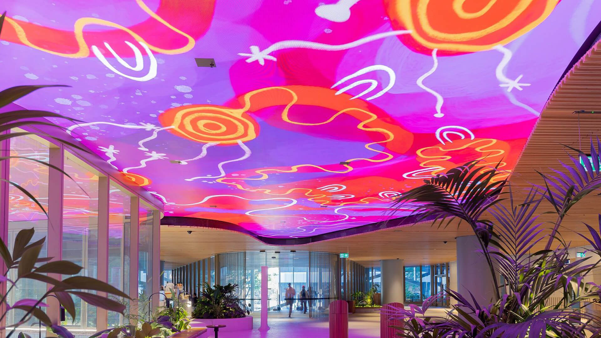 Photo of Mirvac Heritage Lanes commercial lobby foyer in Brisbane Australia showing digital placemaking art screen with vibrant pink indigenous Australian aboriginal artwork created by artist Rachael Sarra in partnership with VANDAL.