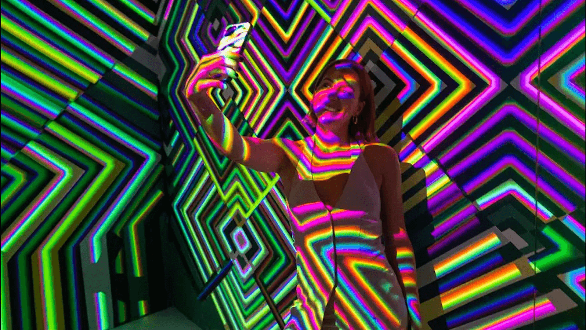 a woman taking a selfie inside an Art of Mixology light installation as part of an experiential brand activation for Kingpin